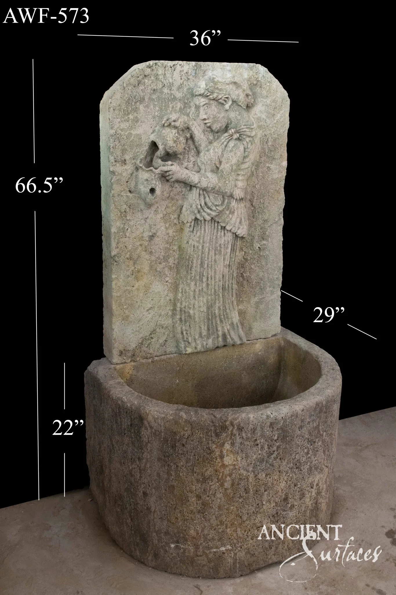 Reclaimed antique limestone wall fountain from Ancient Surfaces catalogued as AWF 573, carved in relief with a robed figure over a round basin, 66.5 inches high