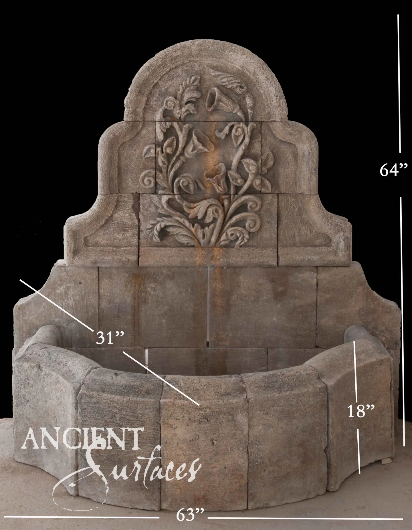 Reclaimed antique limestone wall fountain from Ancient Surfaces carved with a foliate and bird cartouche over a curved barrel shaped basin, 64 inches high